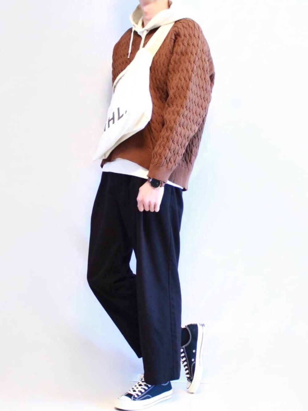 ブラウン系のニット/セーター、ホワイト系のパーカー、ブラック系のその他パンツを着用したメンズの秋コーディネートの1枚目の写真