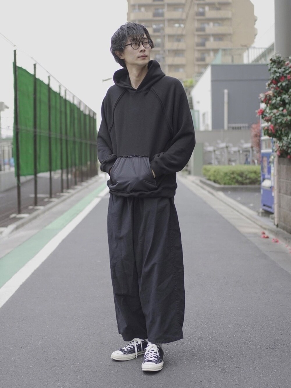 ブラック系のパーカー、ブラック系のカーゴパンツ、ブラック系のスニーカーを着用したメンズの春コーディネートの1枚目の写真