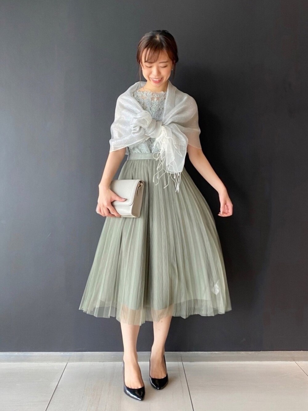 グリーン系のワンピース、グレー系のショルダーバッグ、ブラック系のパンプスを着用したレディースの夏コーディネートの1枚目の写真