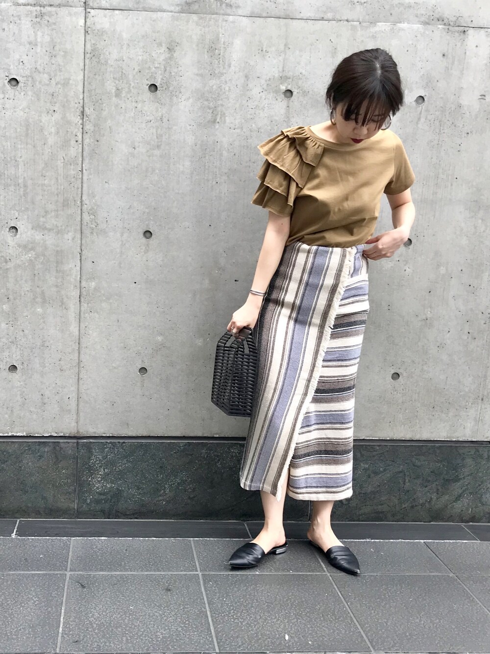 ベージュ系のTシャツ/カットソー、ベージュ系のスカート、ブラック系のかごバッグを着用したレディースの夏コーディネートの1枚目の写真