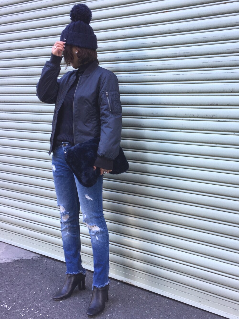 ブルー系のニット/セーター、ブルー系のナイロンジャケット、ブルー系のクラッチバッグを着用したレディースの冬コーディネートの1枚目の写真