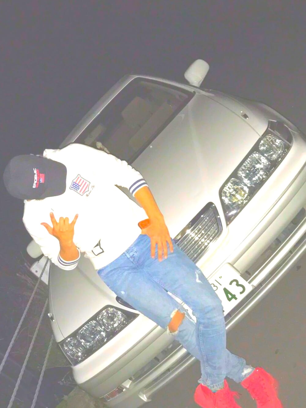 ホワイト系のパーカー、ブルー系のパンツ、レッド系のシューズを着用したメンズの冬コーディネートの1枚目の写真