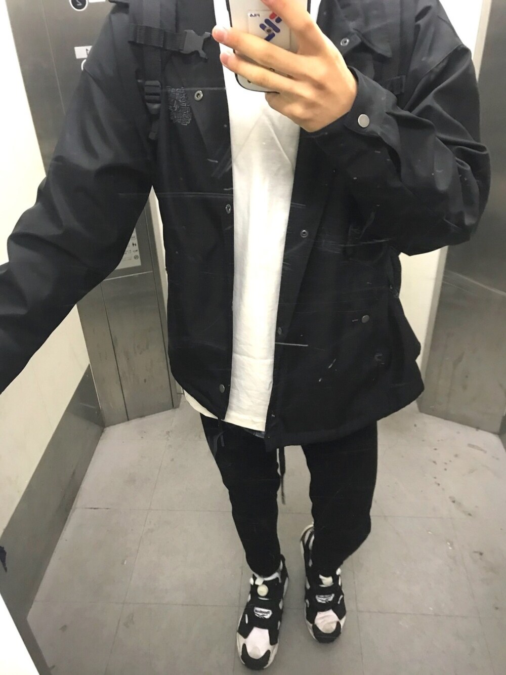 ブラック系のジャケット/アウター、ホワイト系のトップス、ブラック系のデニムパンツを着用したメンズの春コーディネートの1枚目の写真