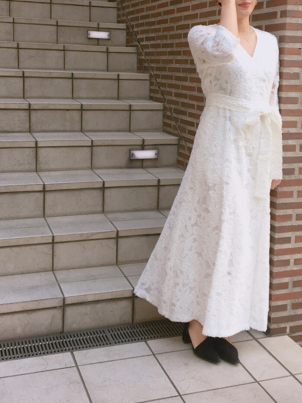 ホワイト系のドレスを着用したレディースの冬コーディネートの1枚目の写真