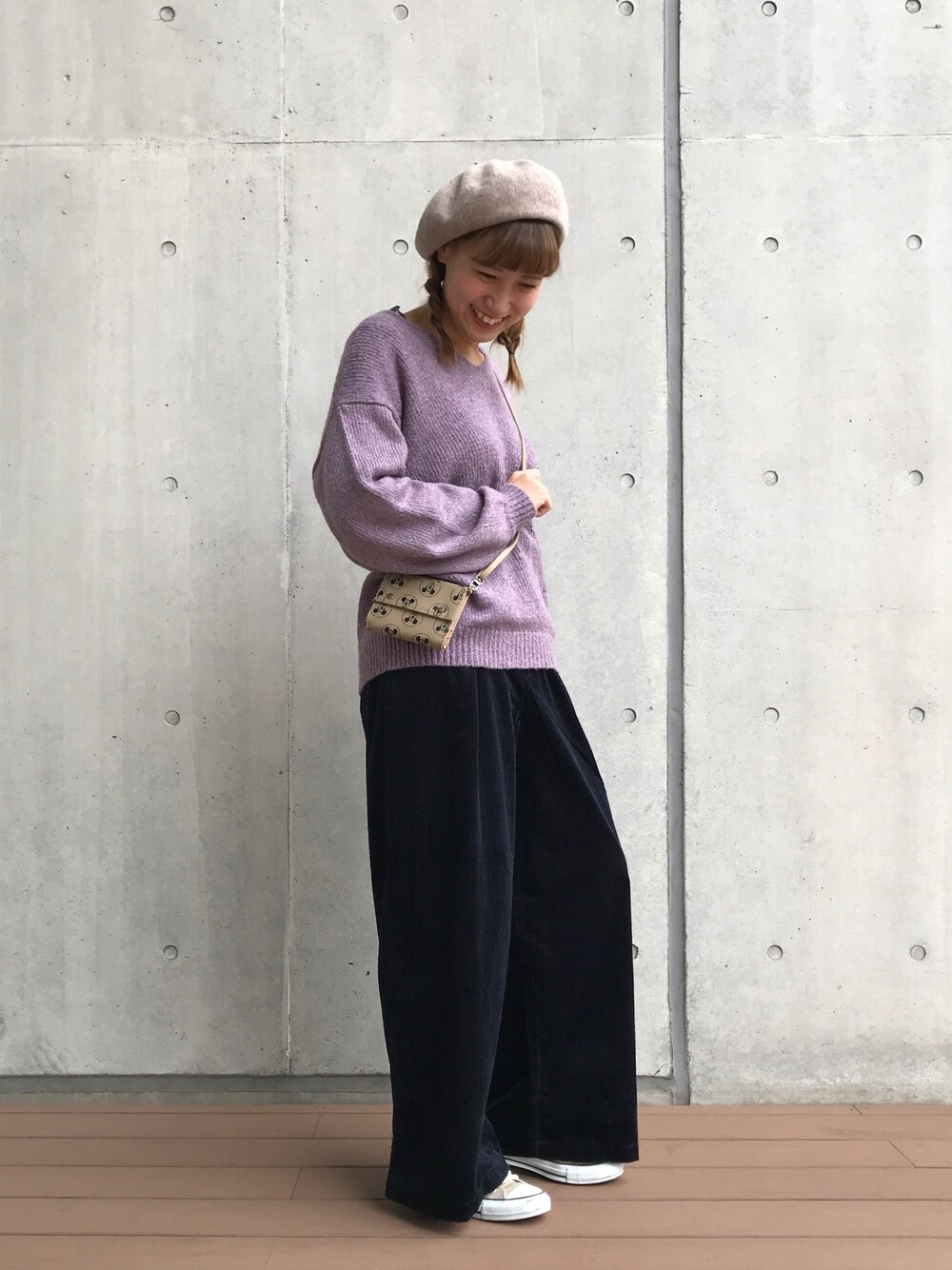 パープル系のニット/セーター、ブルー系のその他パンツ、ベージュ系の財布を着用したレディースの秋コーディネートの1枚目の写真