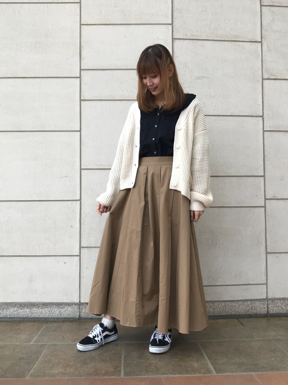 ベージュ系のカーディガン/ボレロ、ブラック系のシャツ/ブラウス、ベージュ系のスカートを着用したレディースの冬コーディネートの1枚目の写真