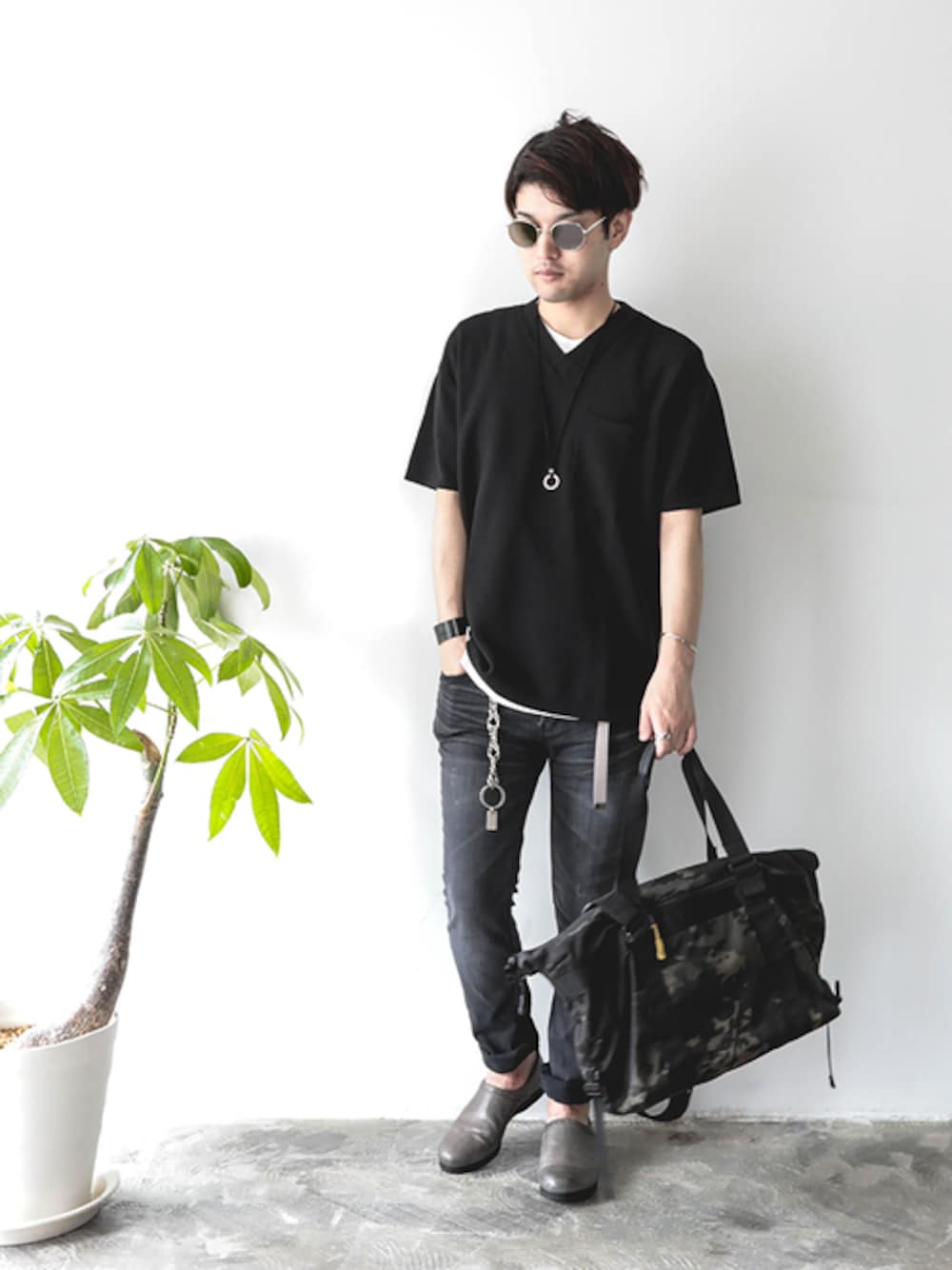 ブラック系のニット/セーター、ホワイト系のTシャツ/カットソー、グレー系のデニムパンツを着用したメンズの夏コーディネートの1枚目の写真