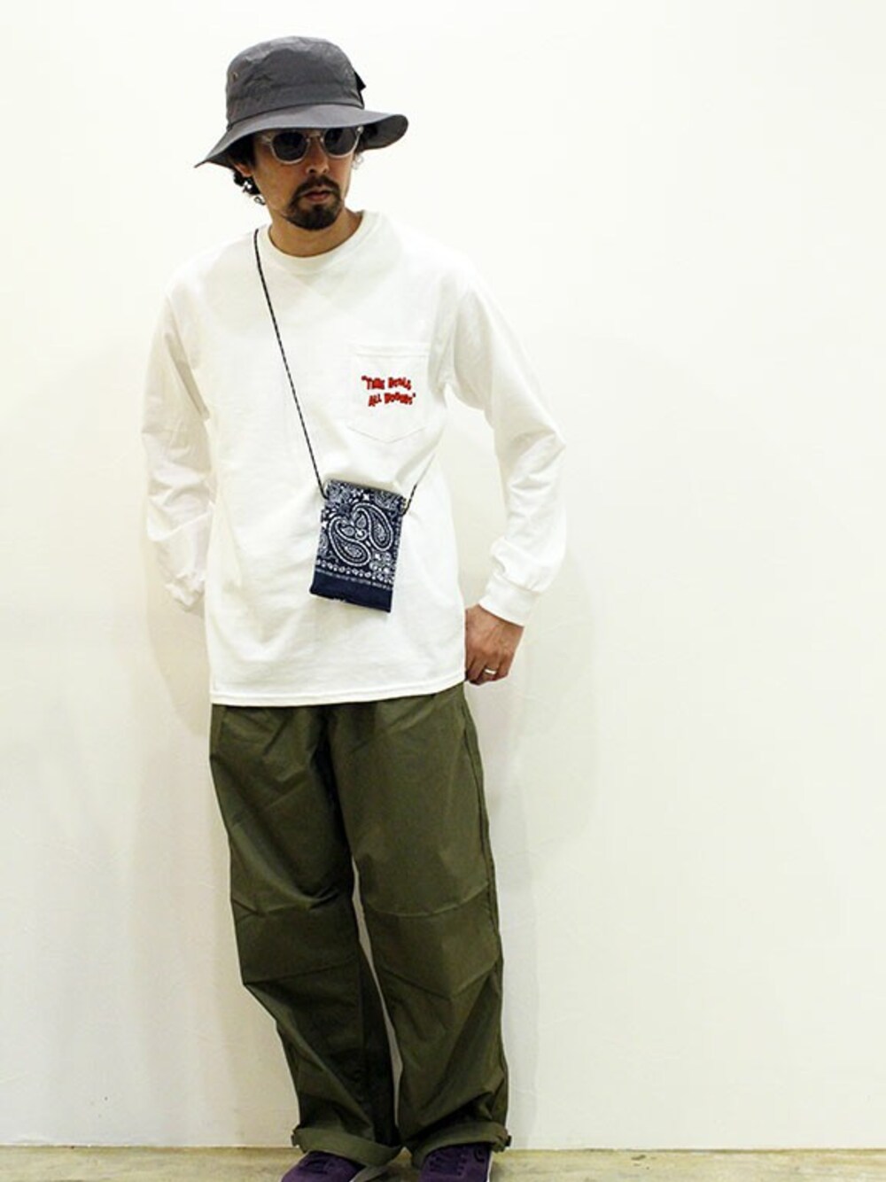 ホワイト系のTシャツ/カットソー、グリーン系のカーゴパンツ、パープル系のスニーカーを着用したメンズの春コーディネートの1枚目の写真