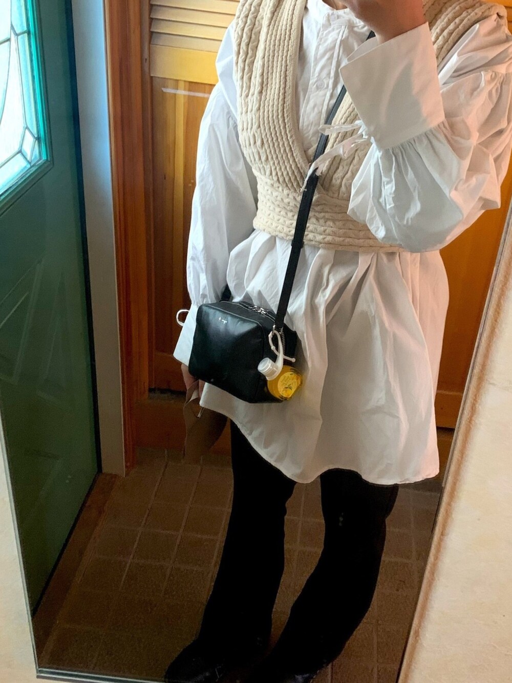 ブラック系のショルダーバッグ、ホワイト系のベスト、ホワイト系のシャツ/ブラウスを着用したレディースの冬コーディネートの1枚目の写真