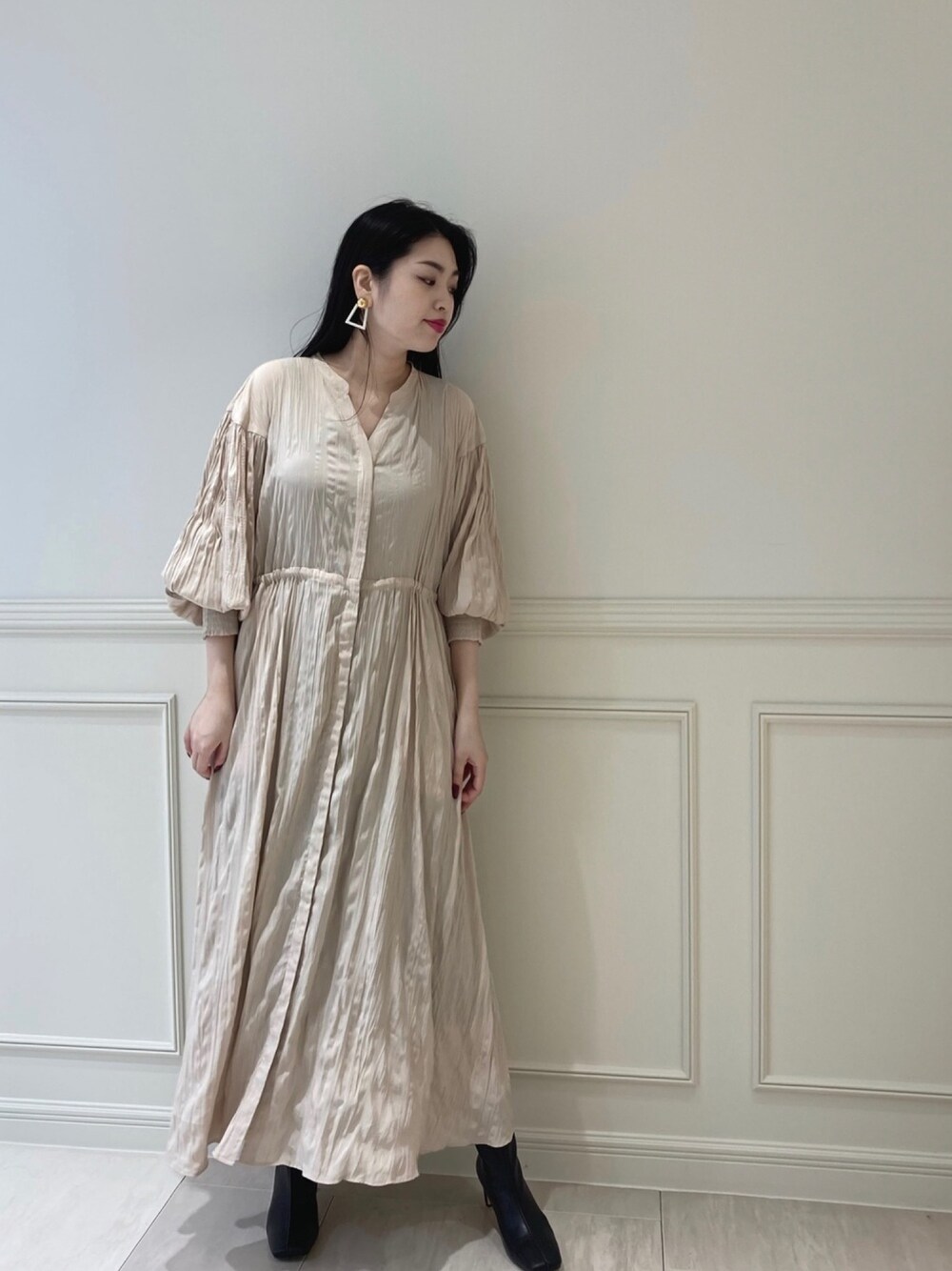 ベージュ系のワンピース、ブラック系のブーツを着用したレディースの秋コーディネートの1枚目の写真