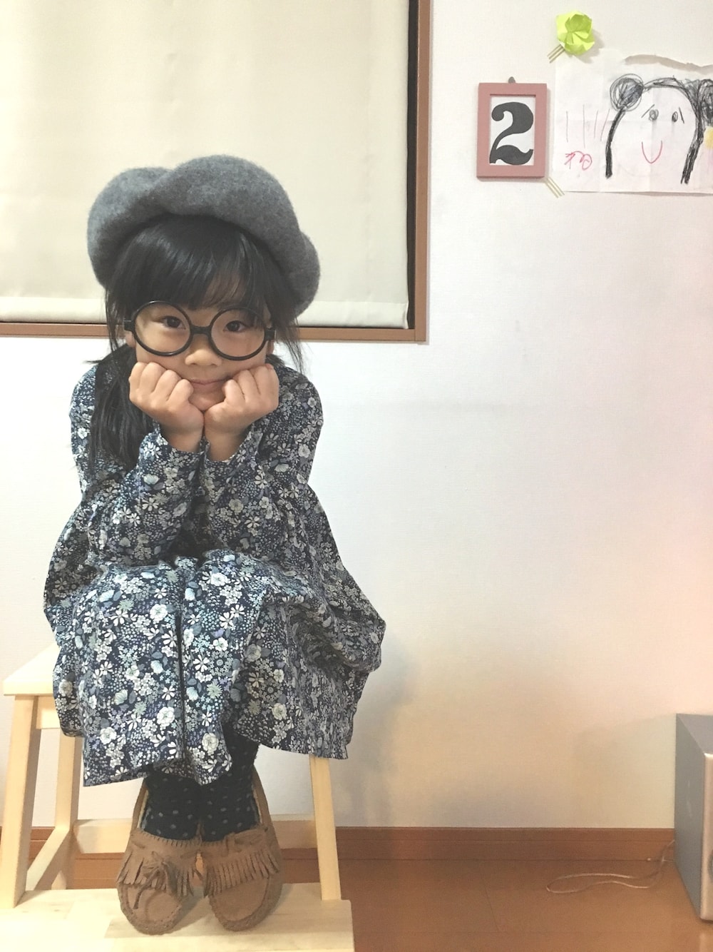 ブルー系のワンピース、ベージュ系のモカシン/デッキシューズ、グレー系のハンチング/ベレー帽を着用したキッズの冬コーディネートの1枚目の写真