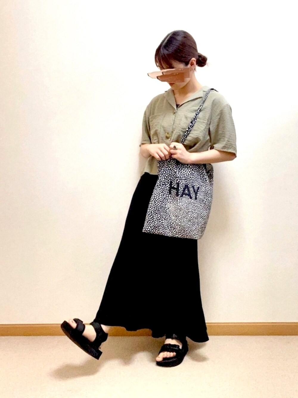 ブラック系のトートバッグ、ブラック系のスカート、グリーン系のシャツ/ブラウスを着用したレディースの夏コーディネートの1枚目の写真