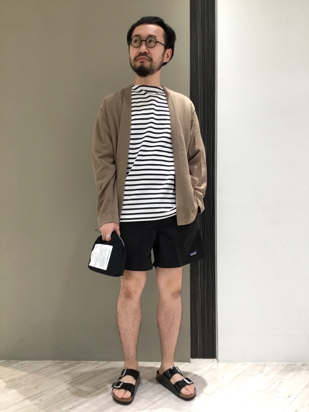 ホワイト系のTシャツ/カットソー、ベージュ系のカーディガン/ボレロ、ブラック系のその他パンツを着用したメンズの春コーディネートの1枚目の写真