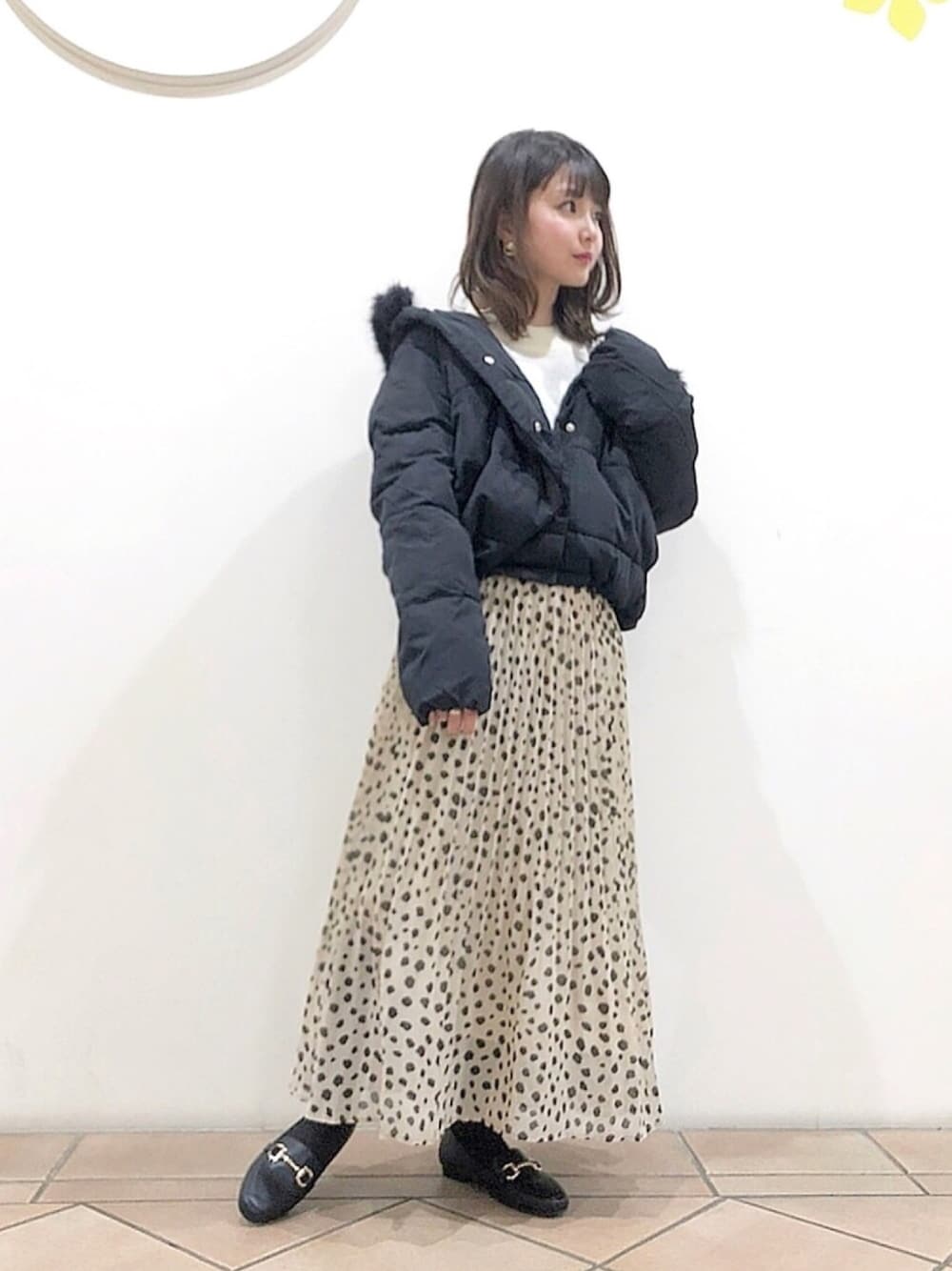 ブラック系のブルゾン、ホワイト系のニット/セーター、ブラック系のローファーを着用したレディースの冬コーディネートの1枚目の写真