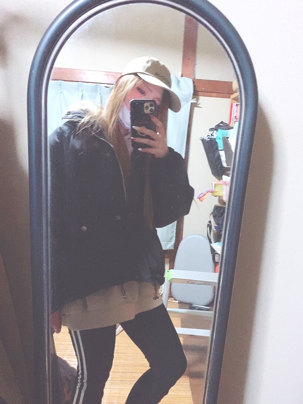 ベージュ系のパーカー、ブラック系のダウンジャケット/コート、ブラック系のその他パンツを着用したレディースの春コーディネートの1枚目の写真