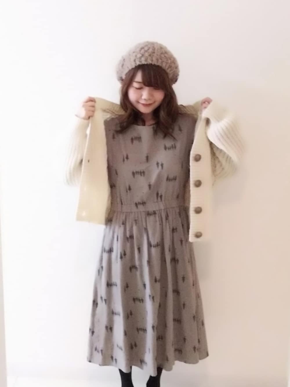 ホワイト系のカーディガン/ボレロ、グレー系のワンピース、ベージュ系のハンチング/ベレー帽を着用したレディースの冬コーディネートの1枚目の写真