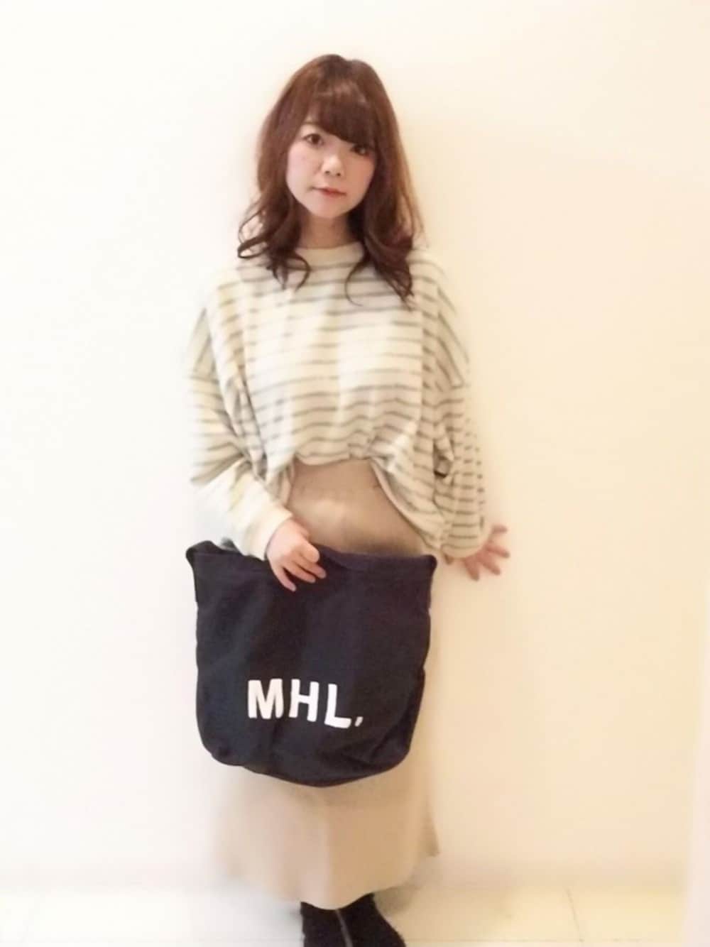 グリーン系のTシャツ/カットソー、ブラック系のショルダーバッグ、ベージュ系のスカートを着用したレディースの冬コーディネートの1枚目の写真