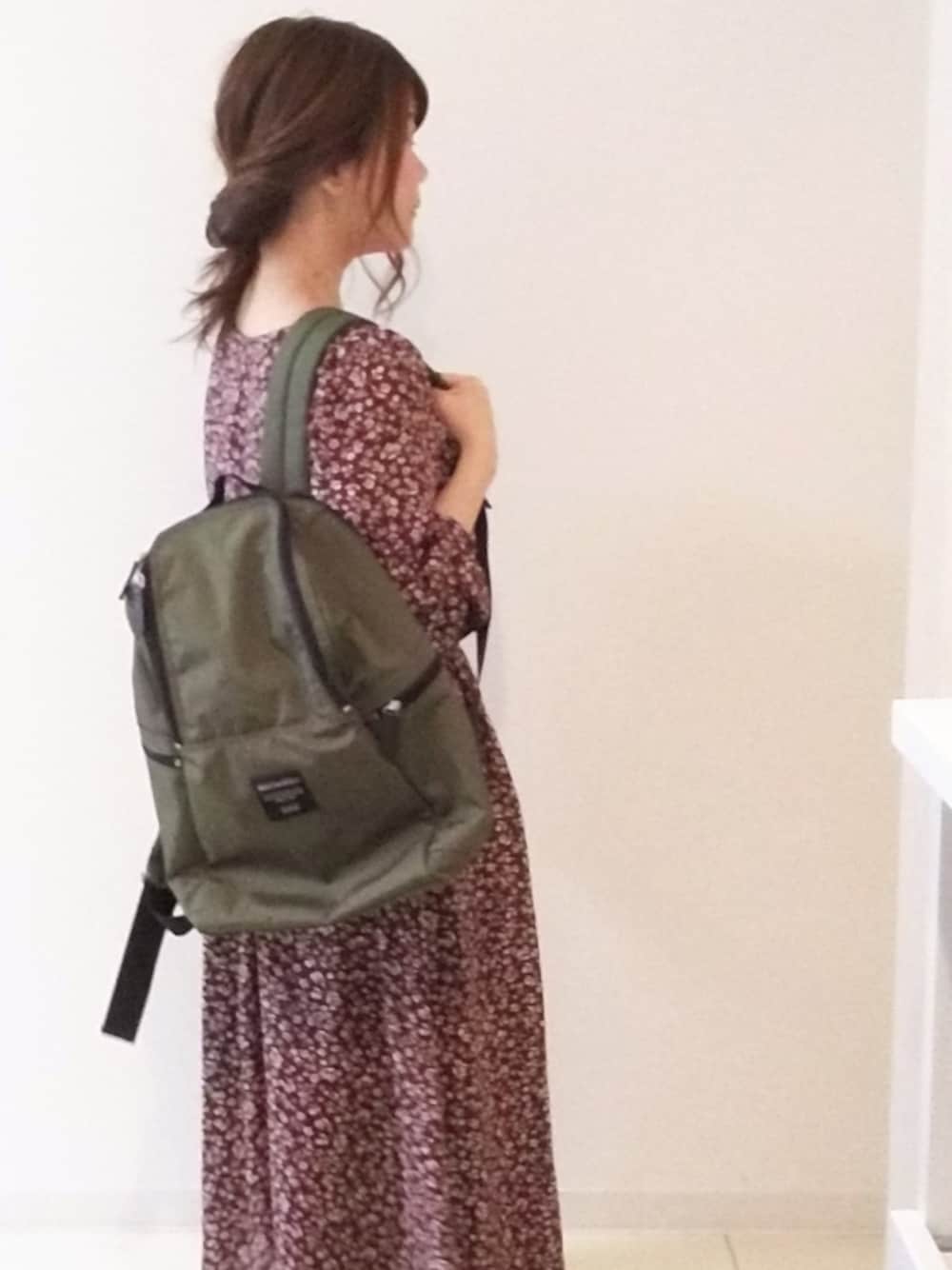 レッド系のワンピース、グリーン系のバックパック/リュックを着用したレディースの冬コーディネートの1枚目の写真