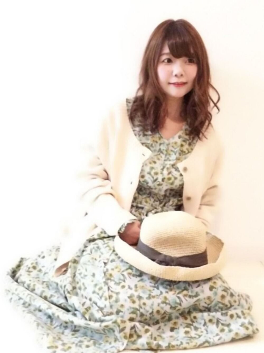 ホワイト系のニット/セーター、グリーン系のワンピース、ベージュ系の帽子を着用したレディースの春コーディネートの1枚目の写真