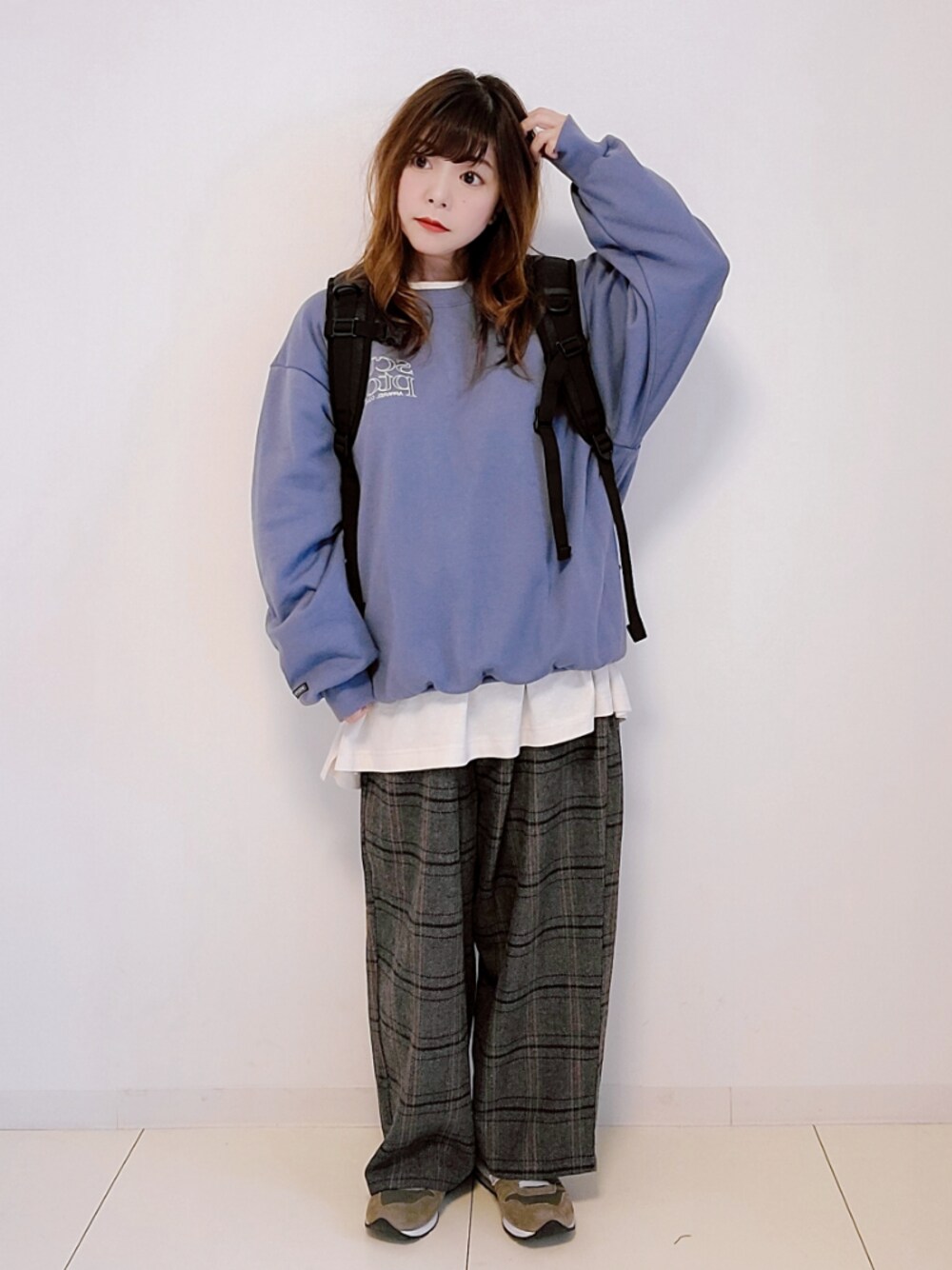 ブルー系のスウェット、ブラック系のバックパック/リュック、ホワイト系のTシャツ/カットソーを着用したレディースの秋コーディネートの1枚目の写真