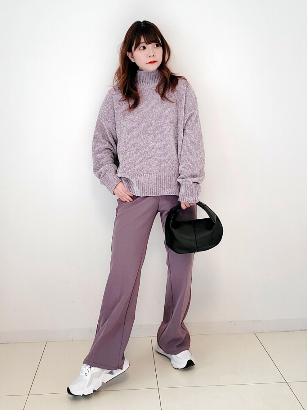 パープル系のパンツ、パープル系のニット/セーター、ブラック系のショルダーバッグを着用したレディースの冬コーディネートの1枚目の写真