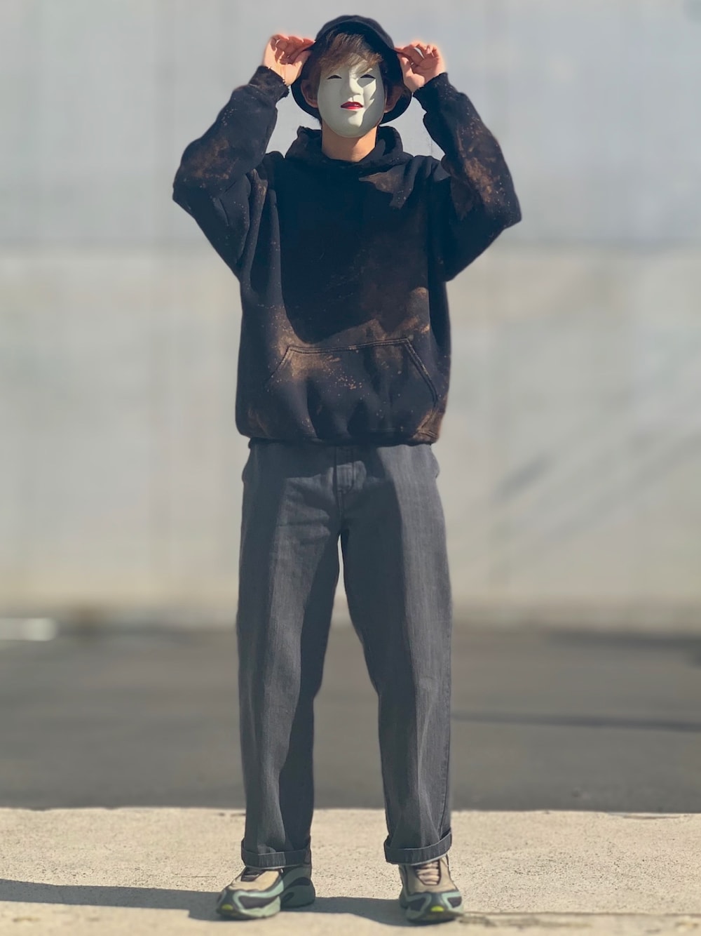 ブラック系のパーカー、ブラック系のデニムパンツ、ベージュ系のスニーカーを着用したメンズの秋コーディネートの1枚目の写真