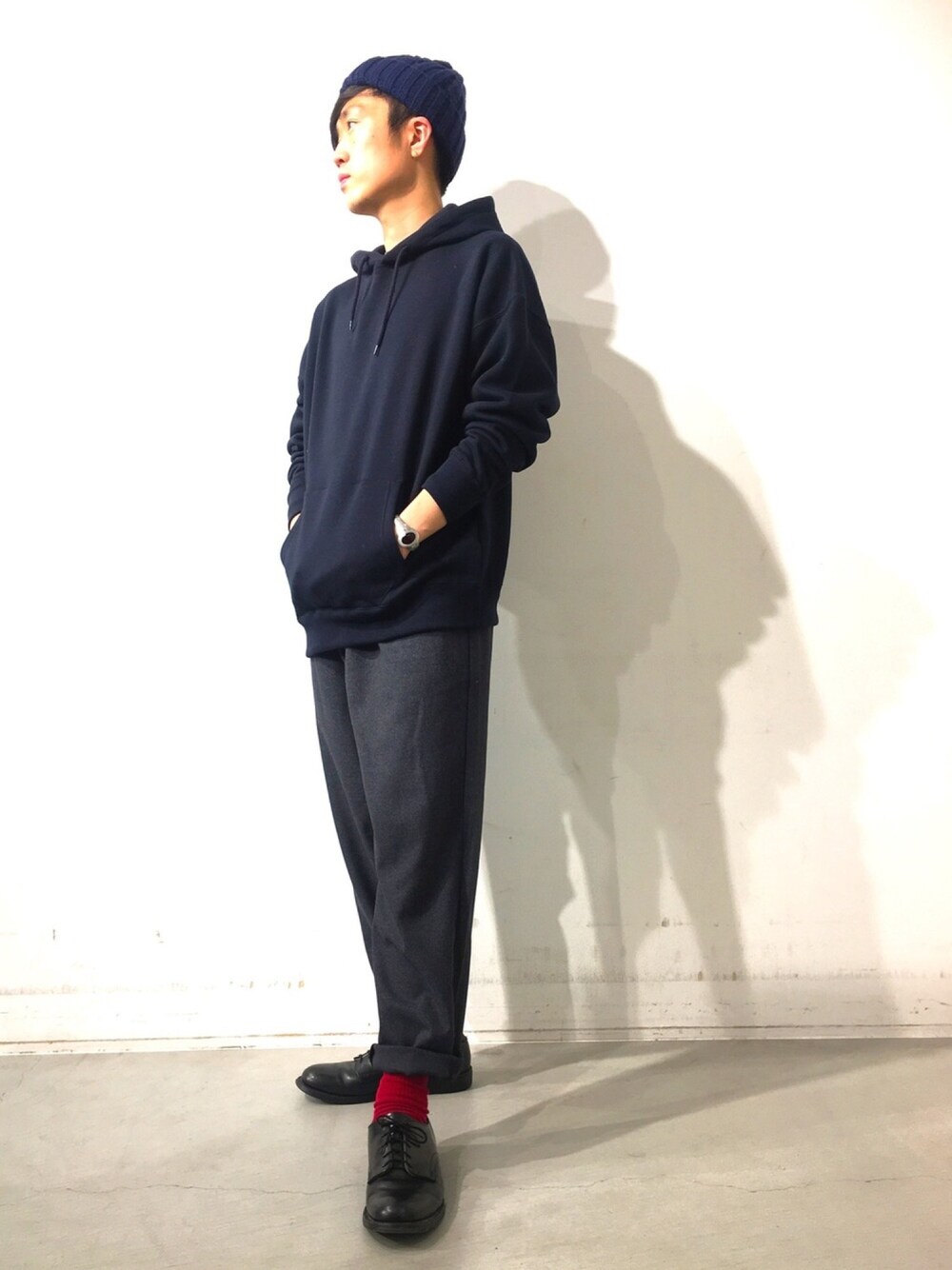 ブルー系のパーカー、グレー系のパンツ、ブラック系のドレスシューズを着用したメンズの冬コーディネートの1枚目の写真