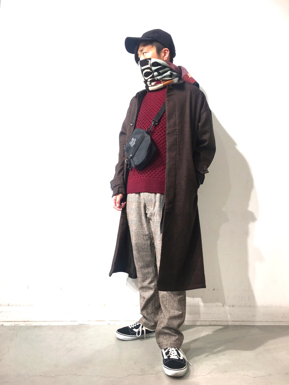 ブラウン系のダウンジャケット/コート、レッド系のニット/セーター、ブラック系のパンツを着用したメンズの冬コーディネートの1枚目の写真