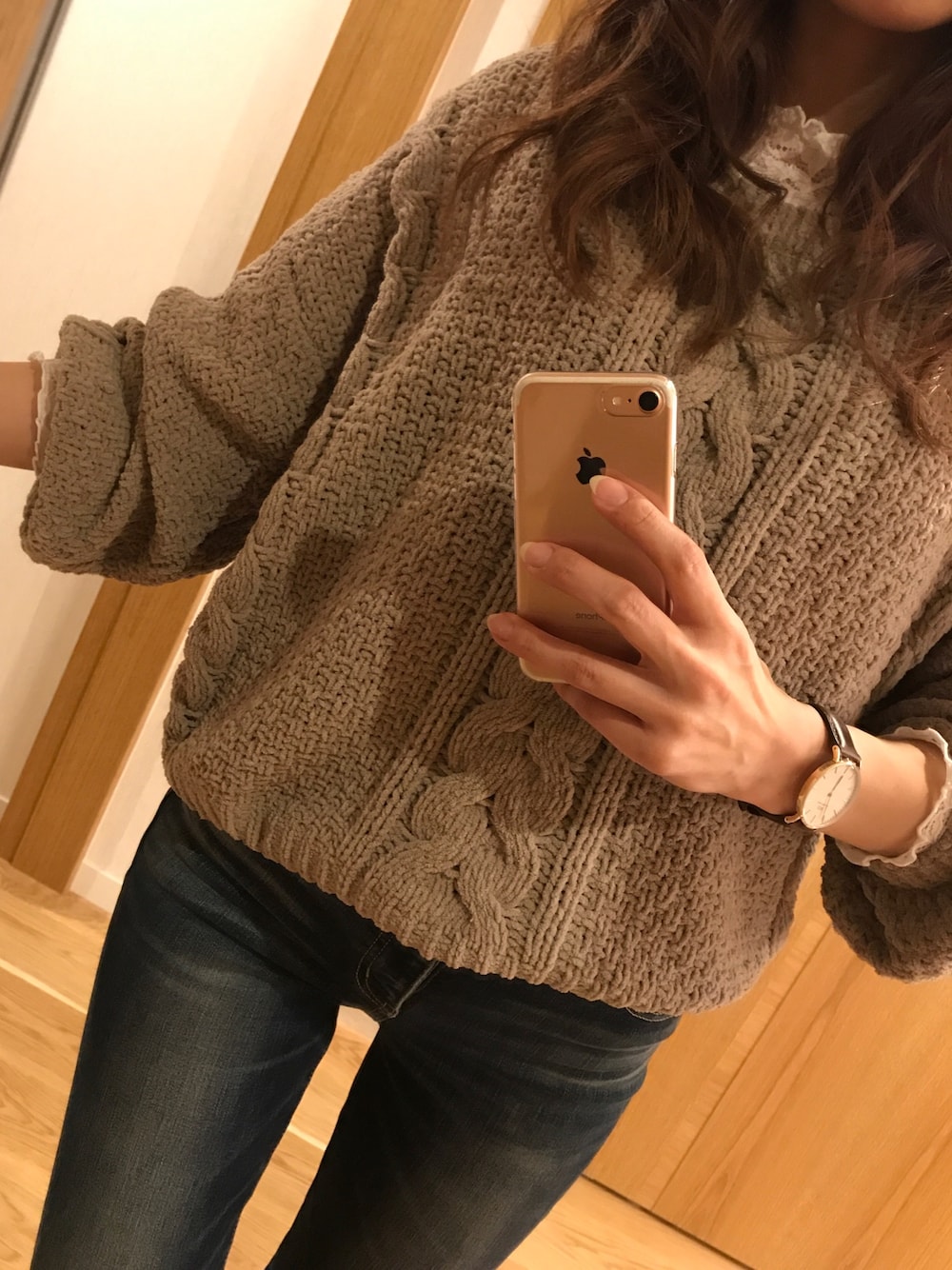 グレー系のニット/セーター、ブルー系のデニムパンツ、ホワイト系のTシャツ/カットソーを着用したレディースの冬コーディネートの1枚目の写真