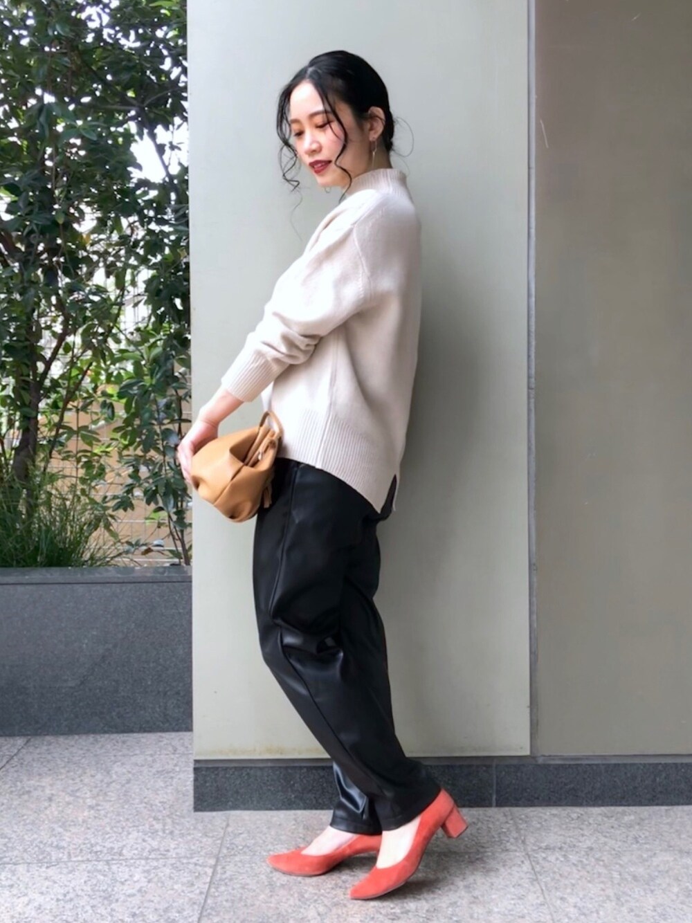 ベージュ系のニット/セーター、ブラック系のパンツ、イエロー系のショルダーバッグを着用したレディースの冬コーディネートの1枚目の写真