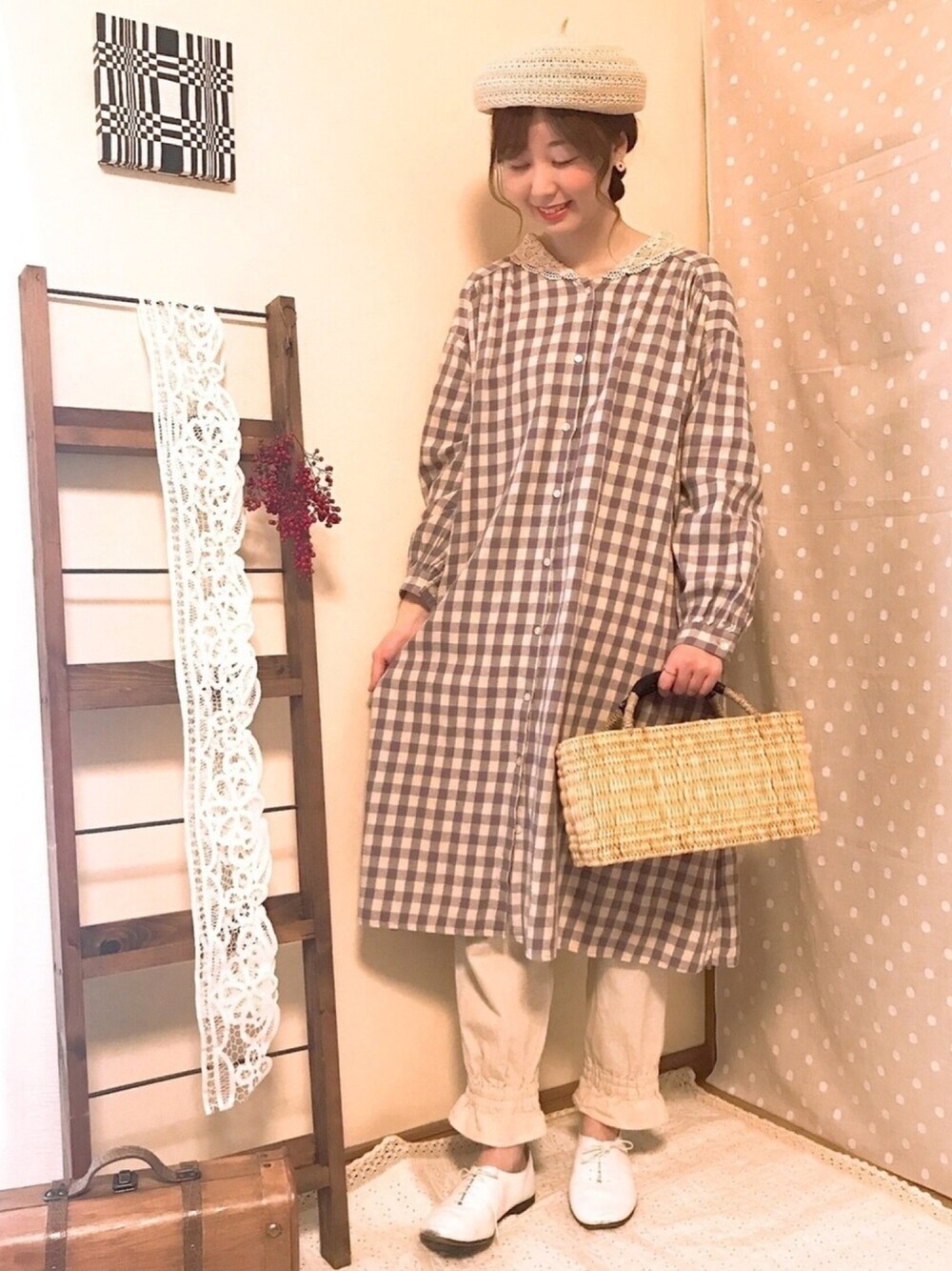 パープル系のワンピース、ブルー系のパンツ、ベージュ系のバッグを着用したレディースの春コーディネートの1枚目の写真