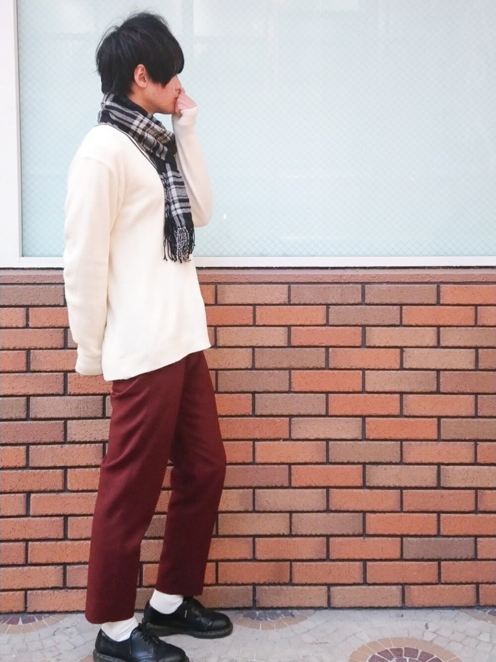 ブラウン系のスラックス、ブラック系のドレスシューズ、ブラック系のマフラーを着用したメンズの冬コーディネートの1枚目の写真