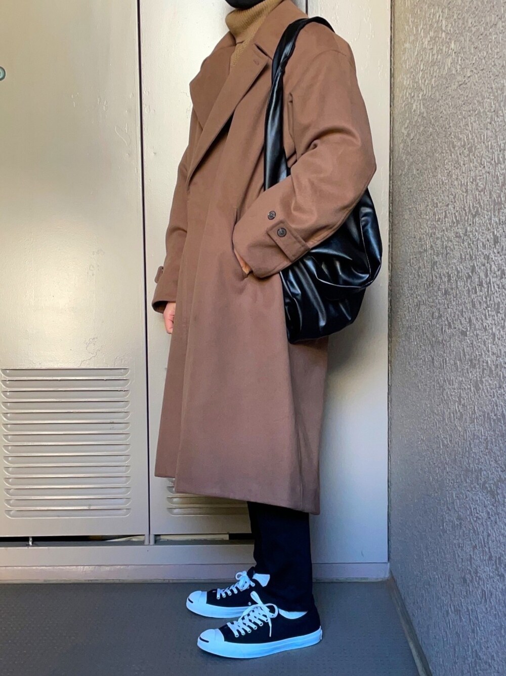 ブラウン系のトレンチコート、ベージュ系のニット/セーター、ブラック系のデニムパンツを着用したメンズの冬コーディネートの1枚目の写真