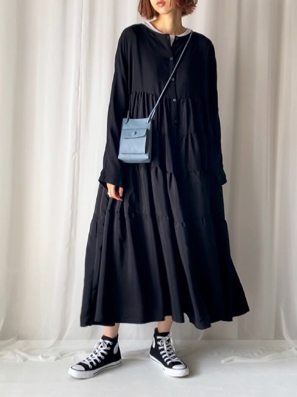 ブラック系のワンピース、ホワイト系のTシャツ/カットソー、ブラック系のスニーカーを着用したレディースの春コーディネートの1枚目の写真