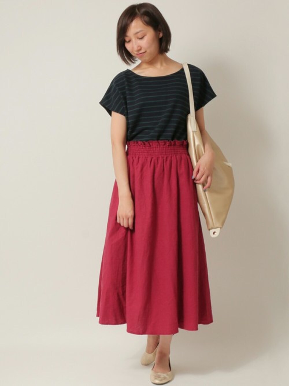 グリーン系のTシャツ/カットソー、レッド系のスカート、その他のショルダーバッグを着用したレディースの秋コーディネートの1枚目の写真