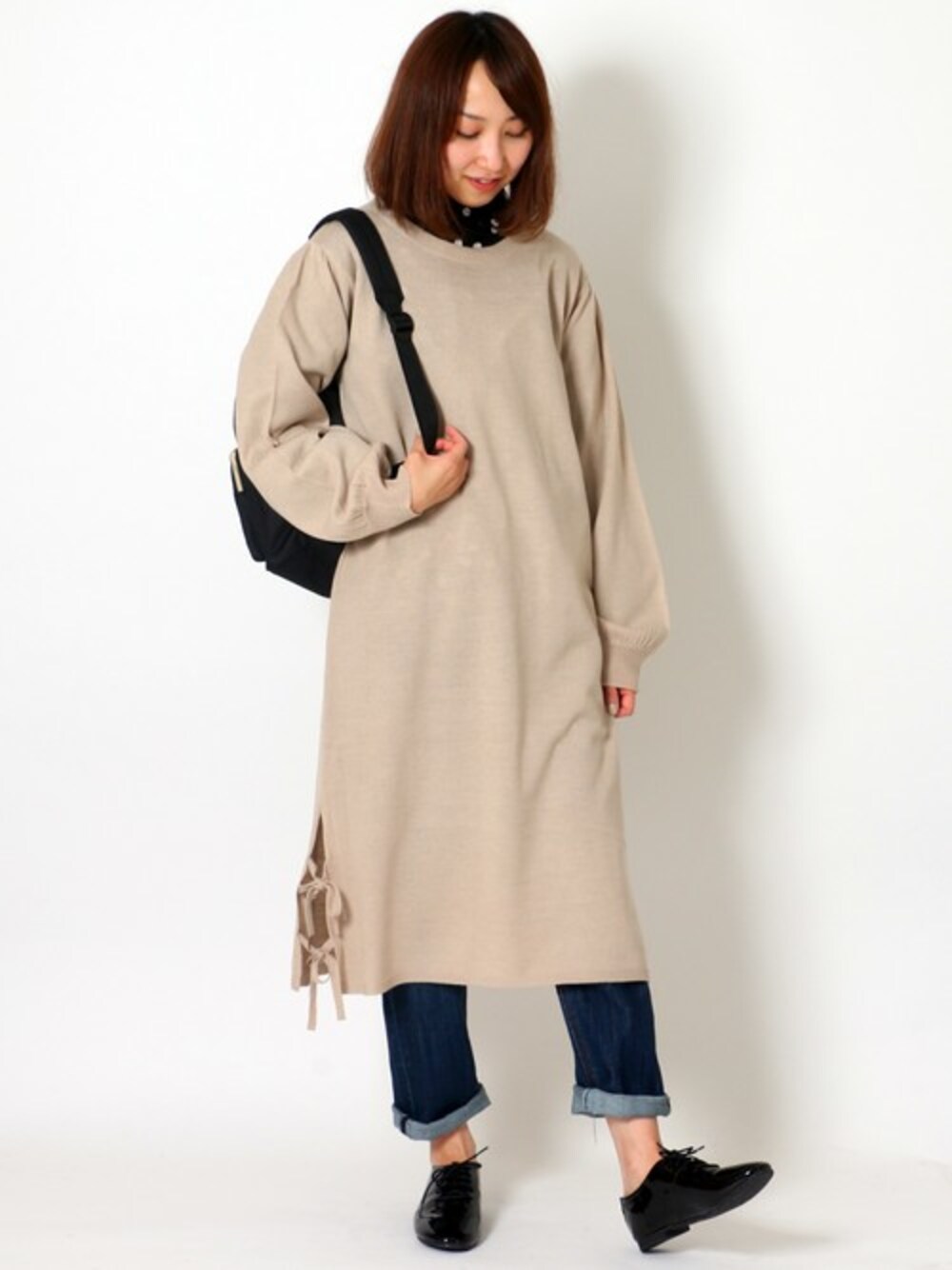 ベージュ系のワンピース、ブラック系のシャツ/ブラウス、ブルー系のデニムパンツを着用したレディースの冬コーディネートの1枚目の写真