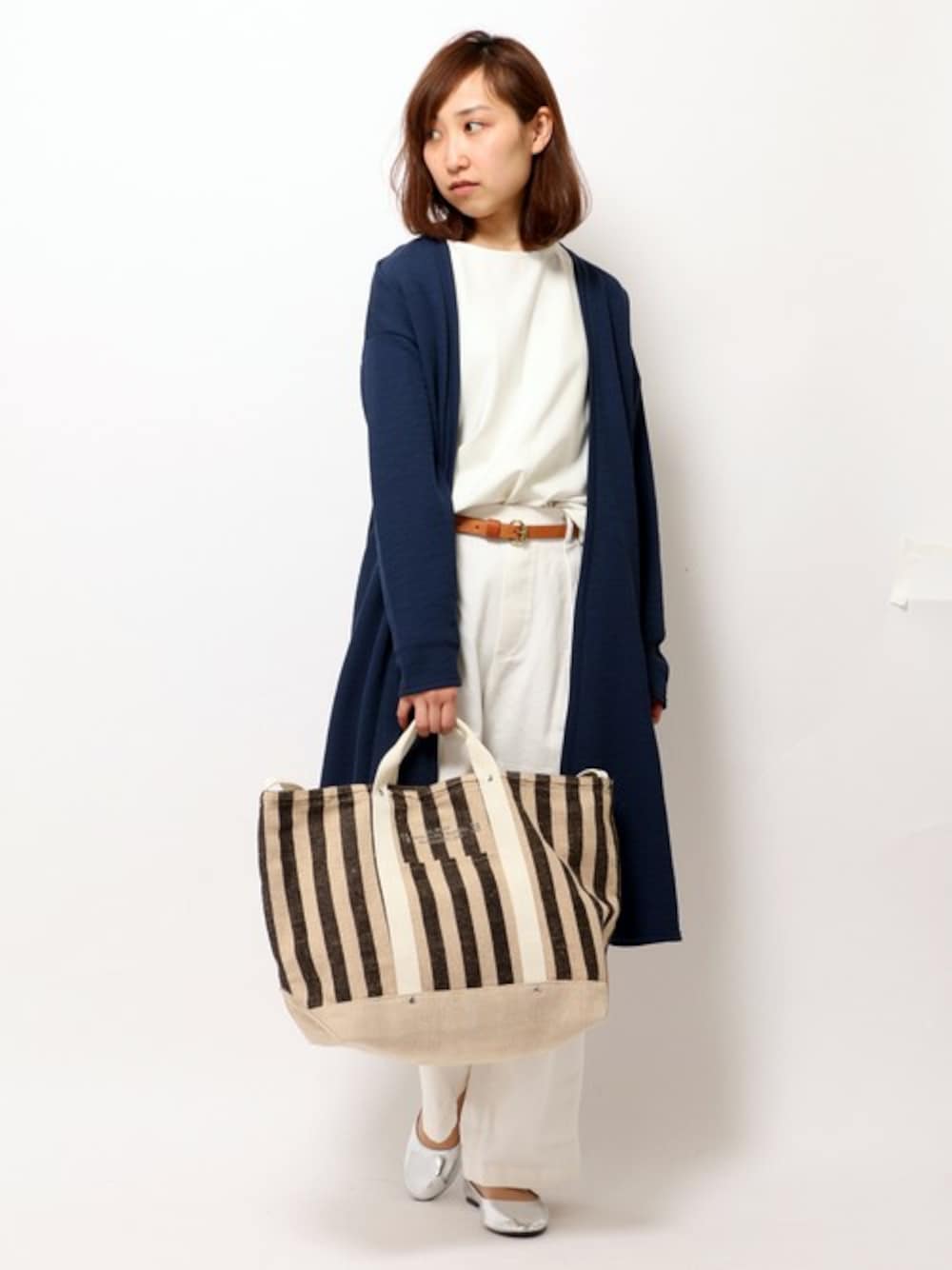 ブラック系のトートバッグ、ブルー系のカーディガン/ボレロ、ホワイト系のTシャツ/カットソーを着用したレディースの春コーディネートの1枚目の写真