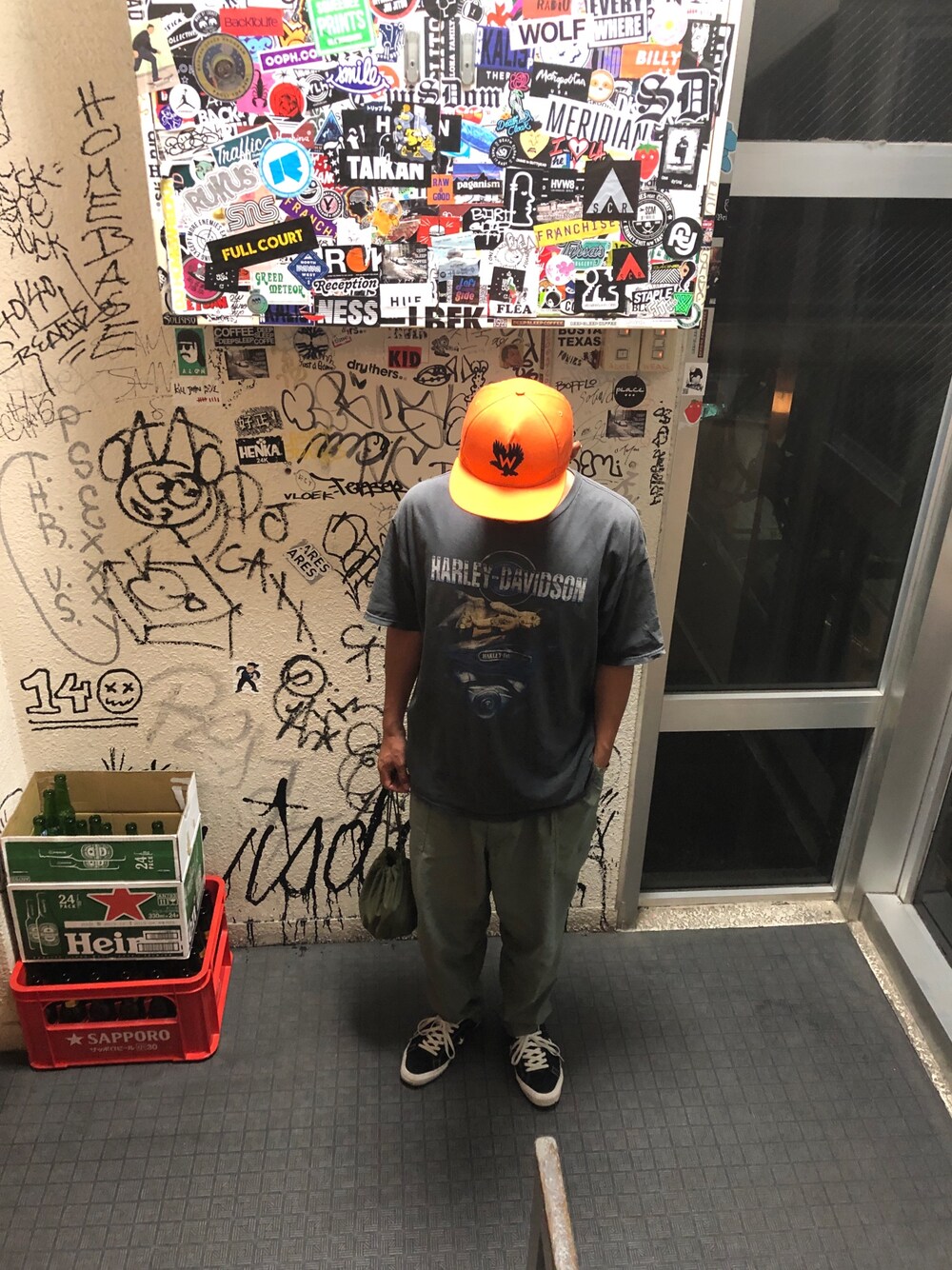 ブラック系のTシャツ/カットソー、グリーン系のカーゴパンツ、ブラック系のスニーカーを着用したメンズの春コーディネートの1枚目の写真