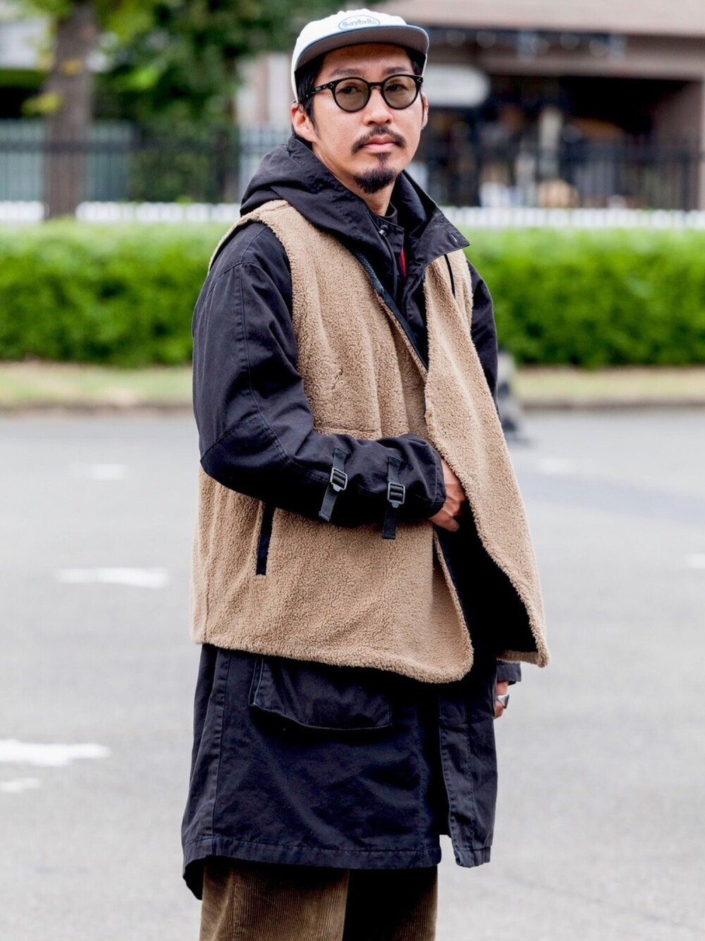 ブラック系のマウンテンパーカー、ブラック系のベスト、グリーン系のその他パンツを着用したメンズの冬コーディネートの1枚目の写真