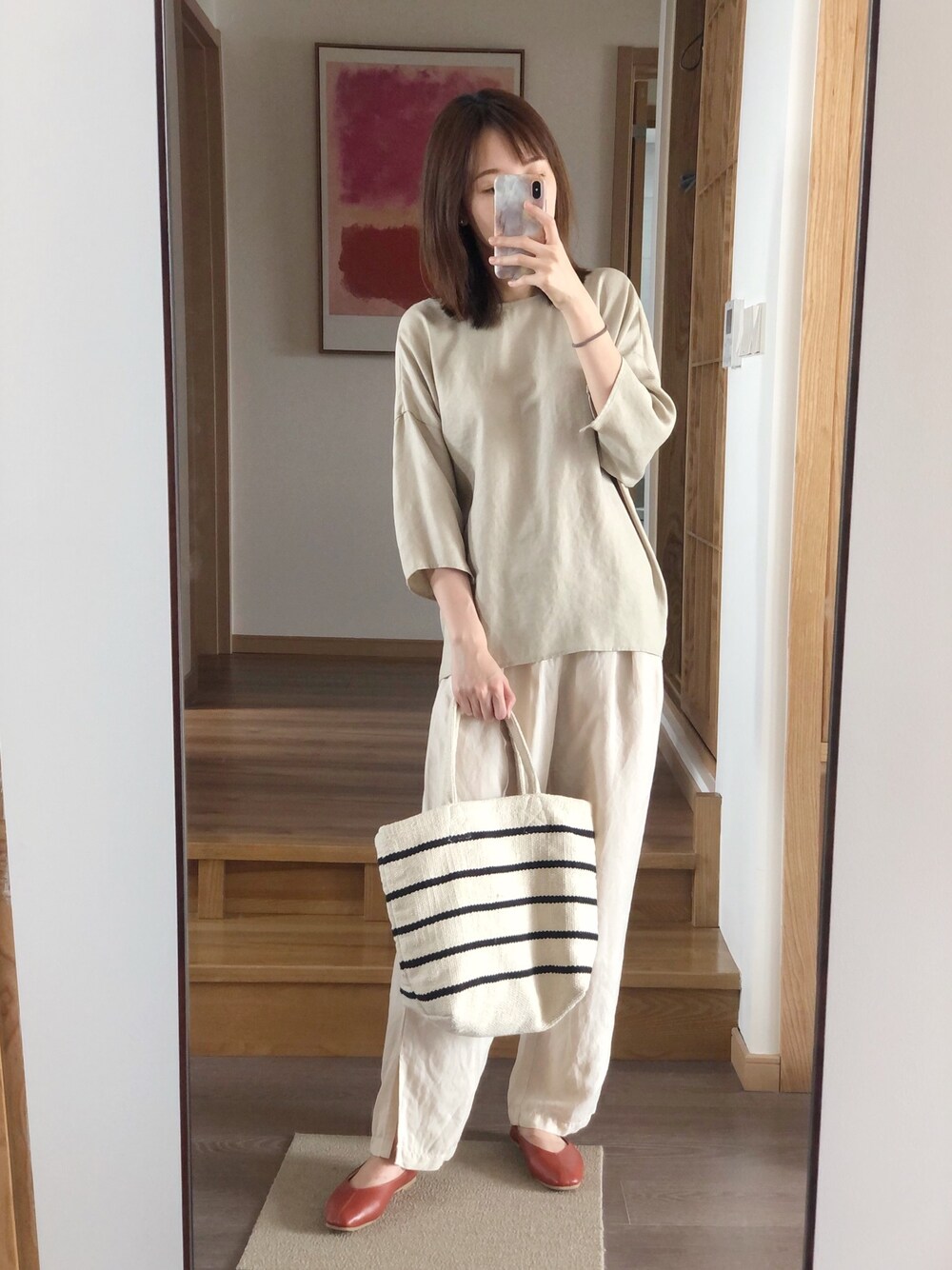 ベージュ系のトップス、ホワイト系のパンツ、ホワイト系のバッグを着用したレディースの夏コーディネートの1枚目の写真