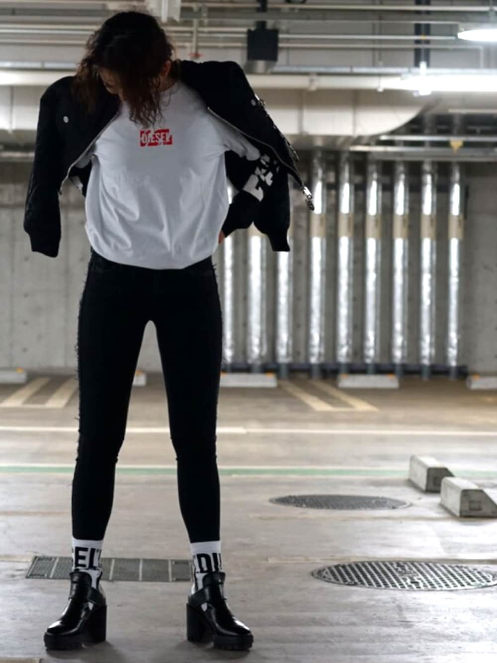 ブラック系のブルゾン、ホワイト系のTシャツ/カットソー、ブラック系のデニムパンツを着用したレディースの冬コーディネートの1枚目の写真