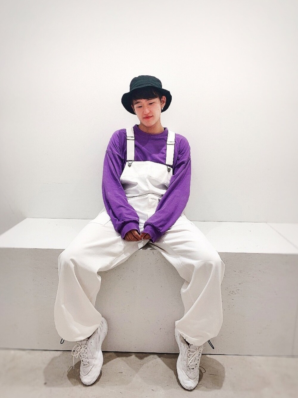 パープル系のTシャツ/カットソー、ホワイト系のつなぎ/オールインワン、ブラック系のハットを着用したメンズの秋コーディネートの1枚目の写真