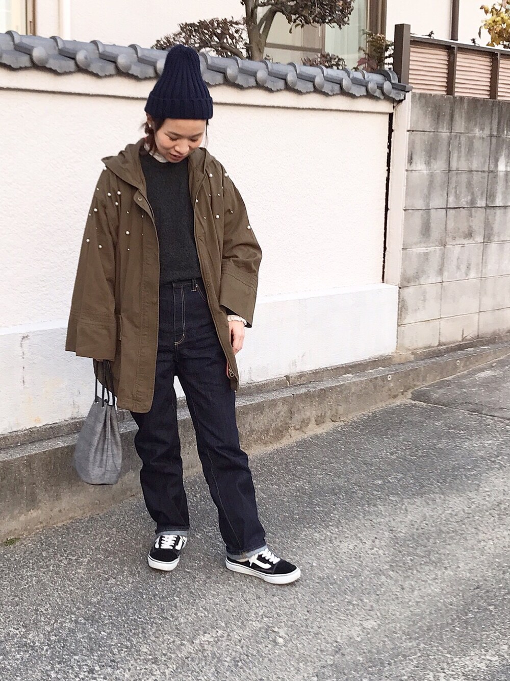 グリーン系のミリタリージャケット、ブルー系のデニムパンツ、ブラック系のスニーカーを着用したレディースの冬コーディネートの1枚目の写真