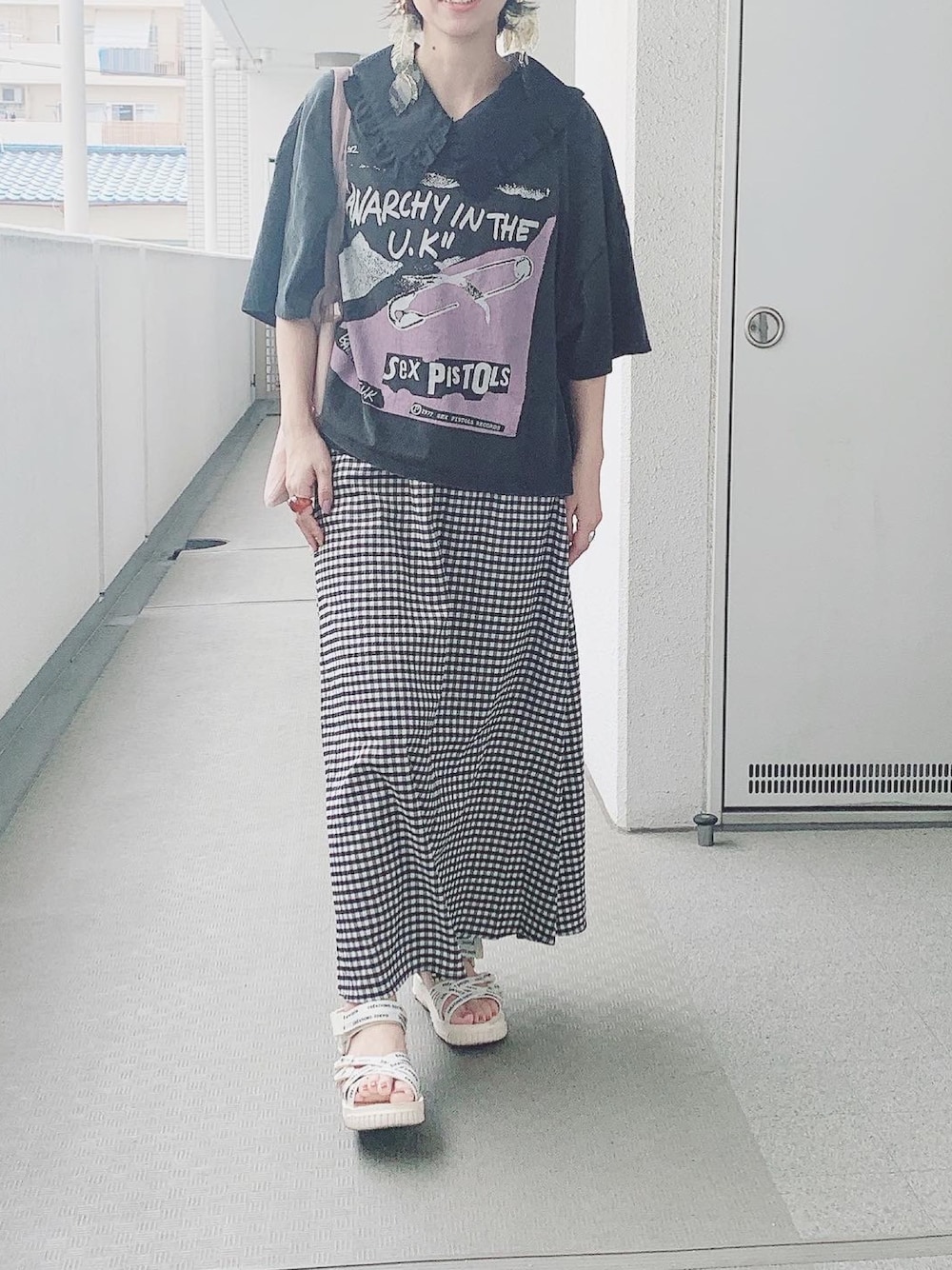 ホワイト系のサンダル、ブラウン系のイヤリングを着用したレディースの夏コーディネートの1枚目の写真