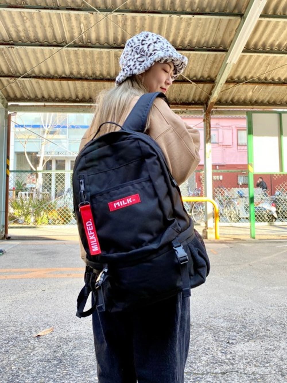 レッド系のバックパック/リュック、ベージュ系のスウェットを着用したレディースの春コーディネートの1枚目の写真