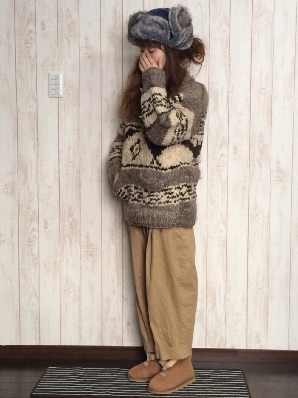 ブラウン系のブーツ、ブラウン系のニット/セーター、ブルー系のニットキャップ/ビーニーを着用したレディースの冬コーディネートの1枚目の写真