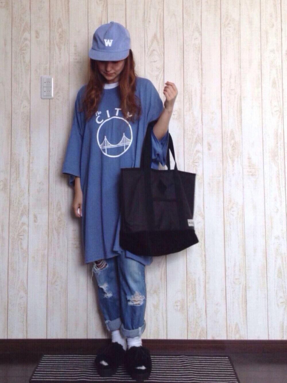 ブラック系のトートバッグ、ブラック系のサンダル、ブルー系のTシャツ/カットソーを着用したレディースの秋コーディネートの1枚目の写真