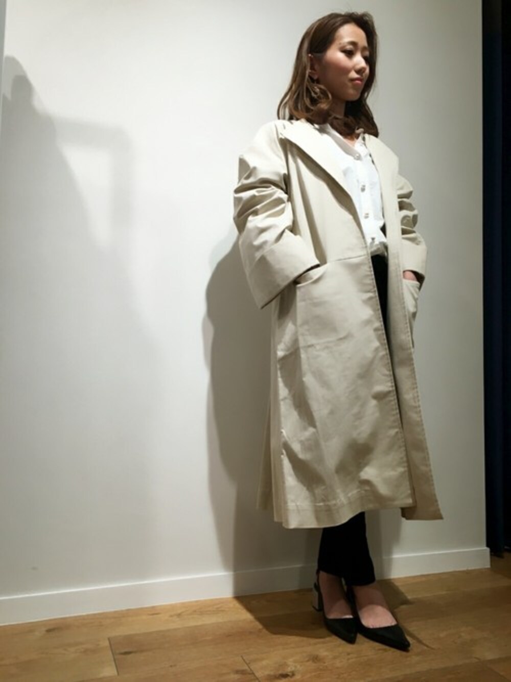 ベージュ系のトレンチコートを着用したレディースの春コーディネートの1枚目の写真