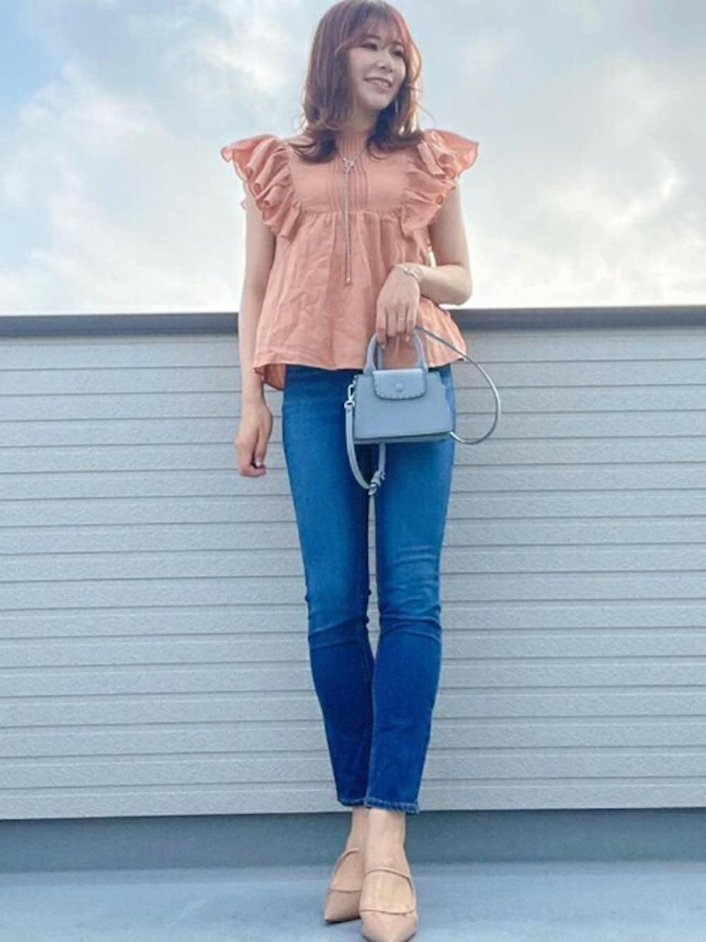 オレンジ系のシャツ/ブラウスを着用したレディースの夏コーディネートの1枚目の写真