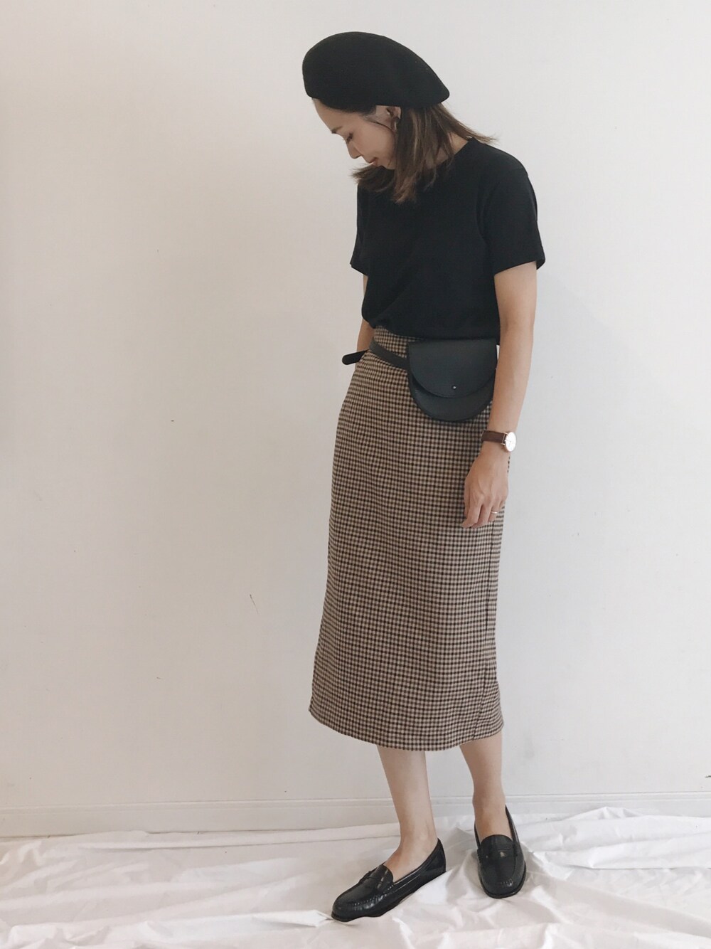 ブラウン系のスカート、ブラック系のボディバッグ/ウエストポーチ、ブラック系のローファーを着用したレディースの夏コーディネートの1枚目の写真